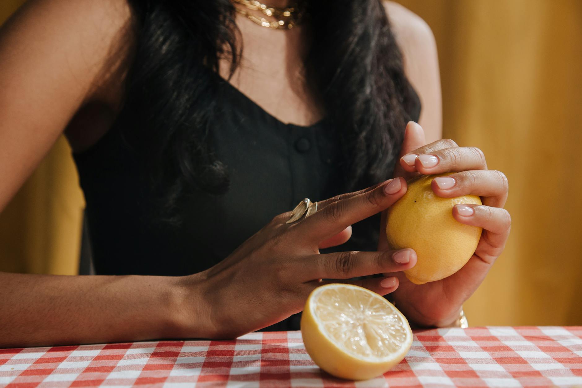 Two fresh lemons held in cupped hands, symbolizing sensitivity and renewal