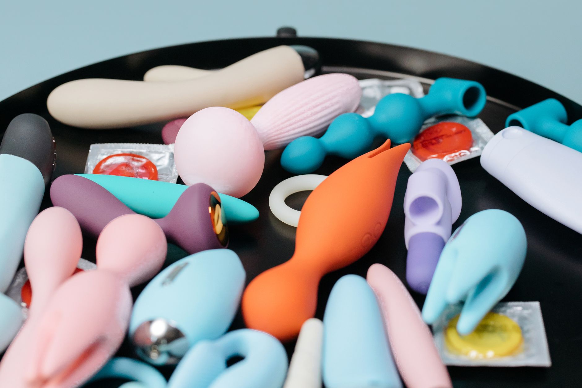 Vibrant sex toys arranged on a bright yellow surface, symbolizing diverse approaches to pleasure and recovery