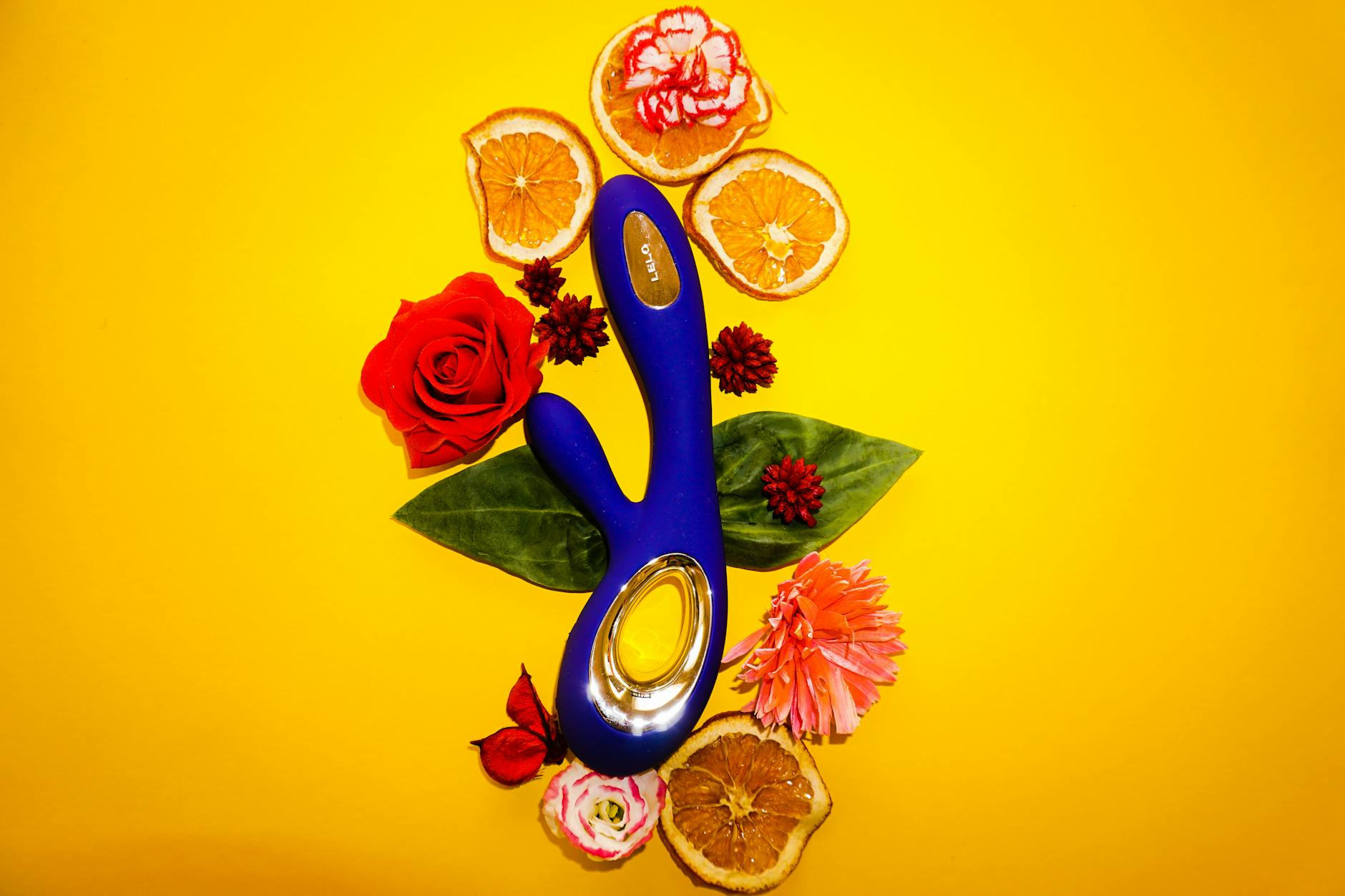 A blue silicone clitoral vibrator held in hand against a solid background, promoting self-care during recovery